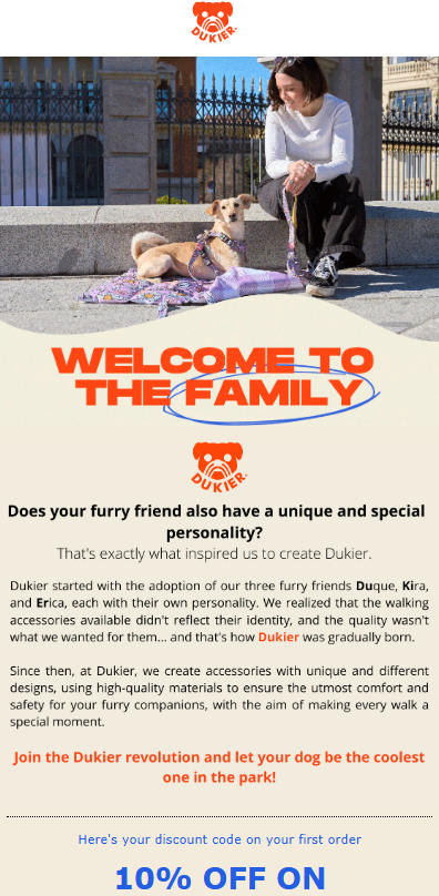 Shopify marketing automation: Three smiling people and three dogs sit together on grass in a park. Text reads “Welcome to the Family” and introduces Dukier, a brand focused on unique, comfy dog accessories. Orange highlights accent the message and offer a discount.