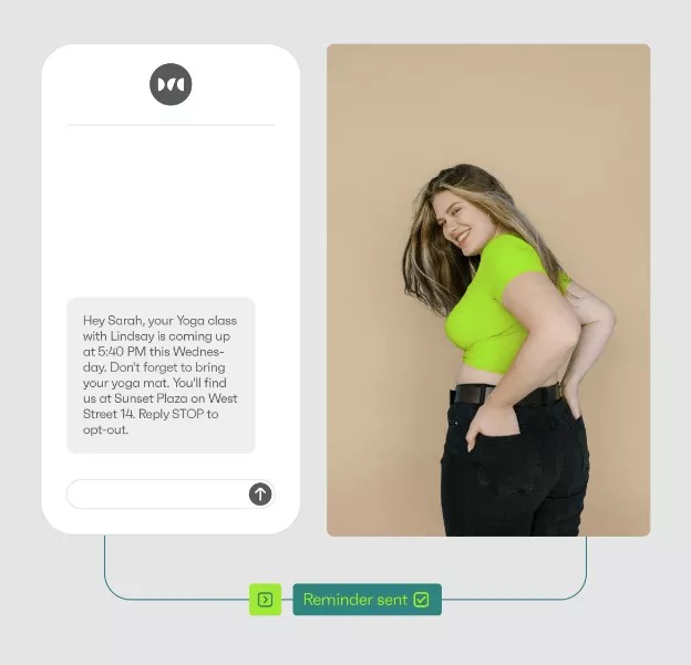 Appointment confirmation text: A phone screen displays a yoga class reminder text message next to a smiling woman with long hair, wearing a neon green top and black pants, standing with her hand on her hip against a beige background.